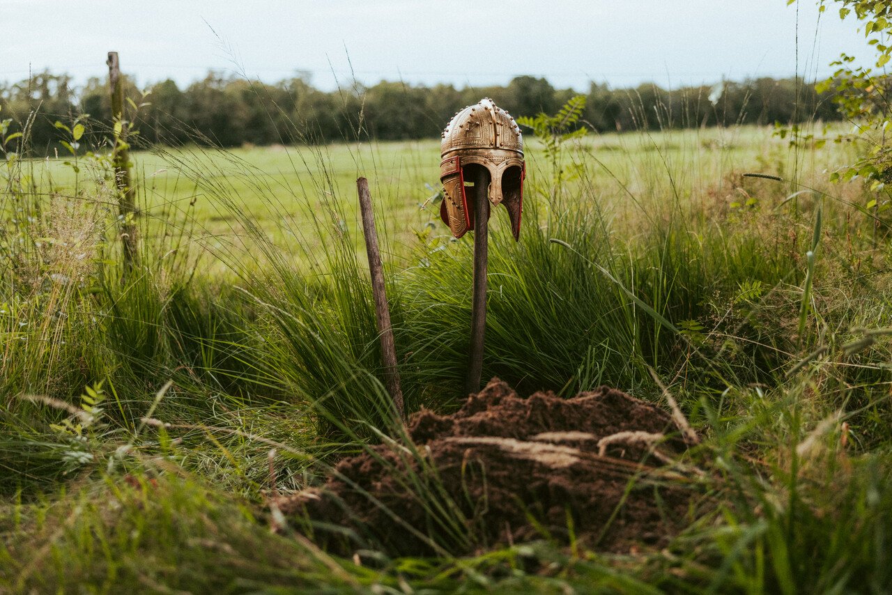 Een gouden helm op een stok in de peel.
