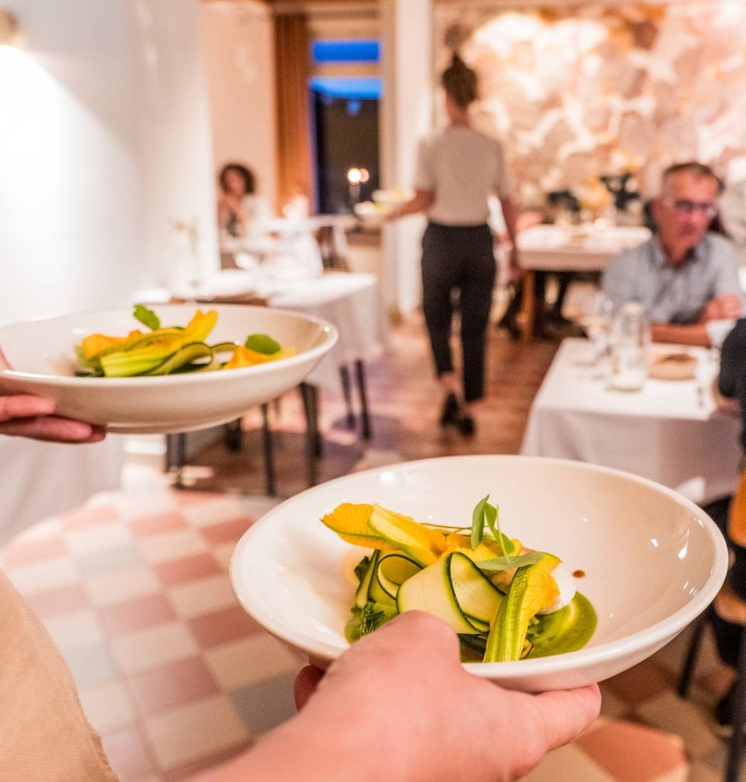 Borden met kleurrijke courgettegerechten worden geserveerd in een sfeervol restaurant in Brabant.