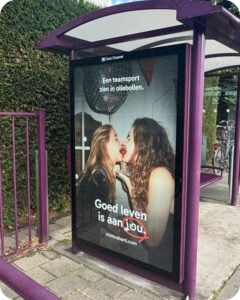 Abri met poster van campagne Goed Leven van Brabant Partners met twee vrouwen die samen een oliebol eten in Brabant.