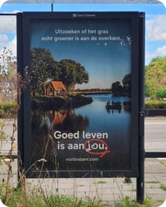 Abri met campagneposter van Goed Leven van Brabant Partners, met rustiek huisje en vissers aan een rivier in Brabant.